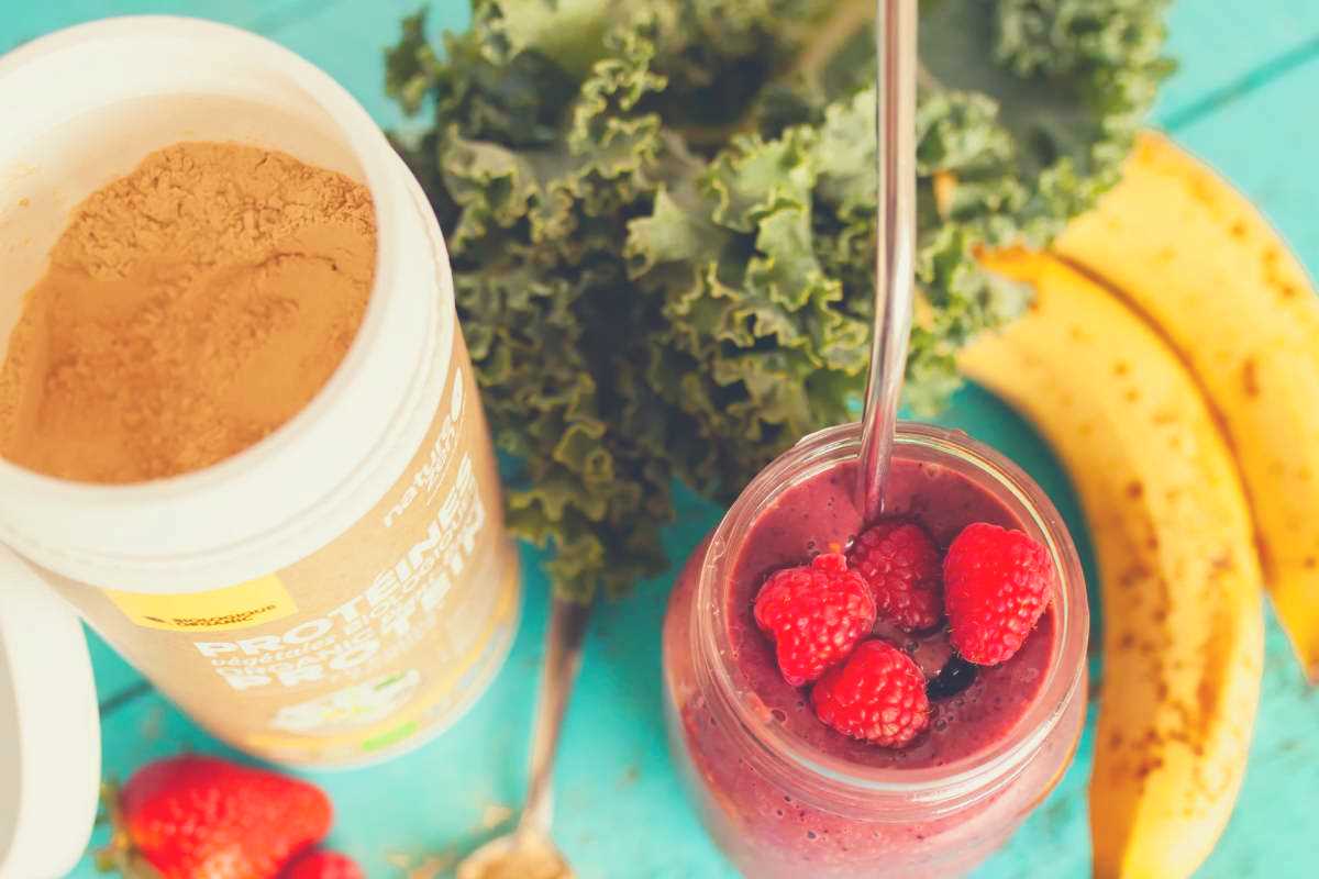 strawberries, kale, bananas and protein powder combined into a protein shake